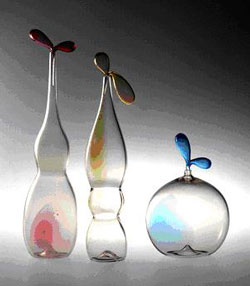 Bottiglia “Zeffiro” in vetro trasparente fumé soffiato e modellato a caldo con sbuffi colorati rubino. Disegno Luciano Gaspari Esecuzione Salviati & C. 1982